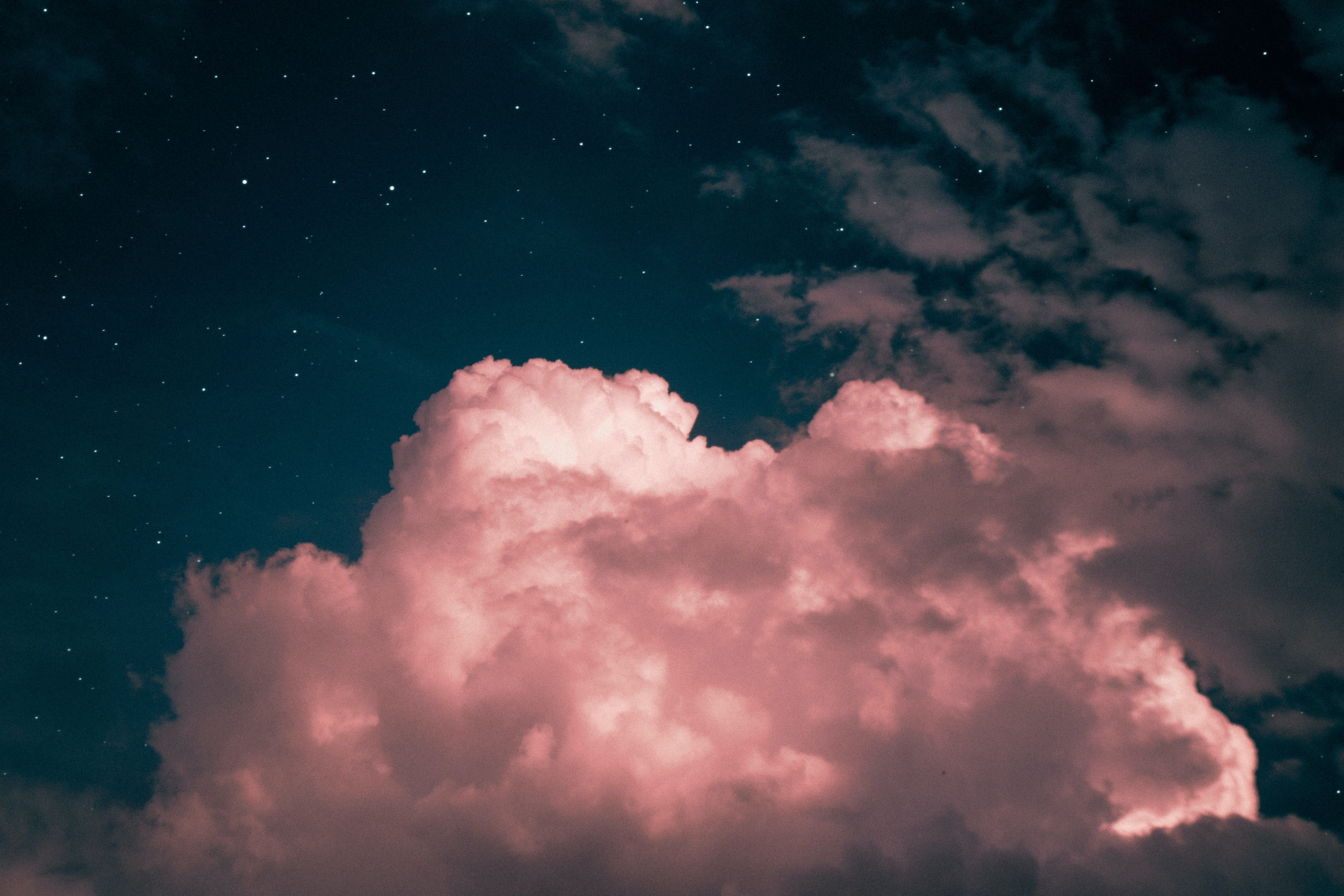 Pink cloud in a dark and starry sky.